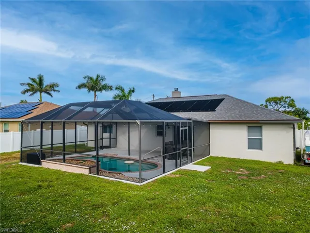 Back of property with glass enclosure, a sunroom, stucco siding, and a shingled roof