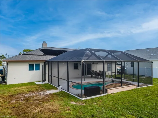 Back of house with an outdoor pool, a lanai, a chimney, and a sunroom
