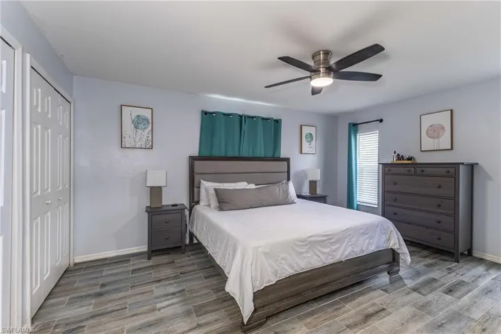 Bedroom with ceiling fan, wood finish floors, and a closet