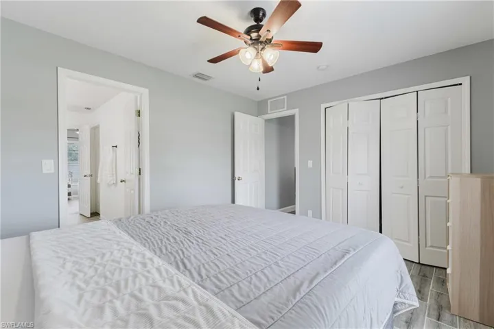 Bedroom with wood tiled floors, a closet, and a ceiling fan