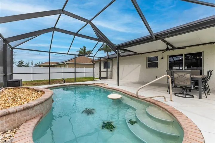 View of swimming pool featuring a sunroom, glass enclosure, and a patio