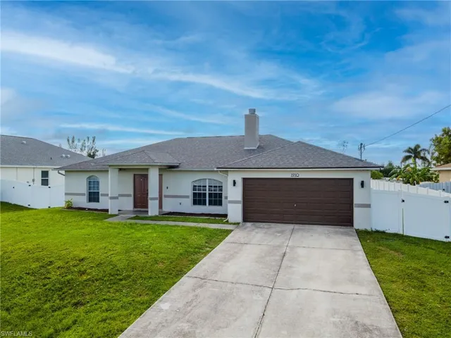 Single story home featuring a shingled roof, stucco siding, a gate, driveway, and a chimney