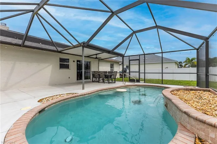 View of swimming pool featuring a sunroom, a lanai, and a patio