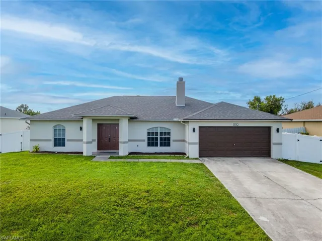 Ranch-style home with a chimney, stucco siding, a gate, and driveway