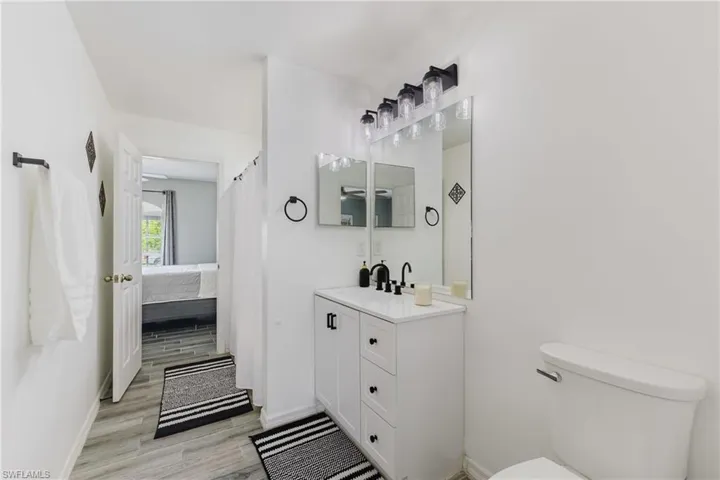 Ensuite bathroom featuring vanity, light wood finished floors, and a shower with shower curtain