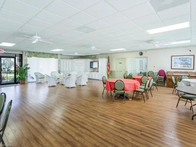Dining room featuring hardwood / wood-style flooring, ceiling fan, and a drop ceiling