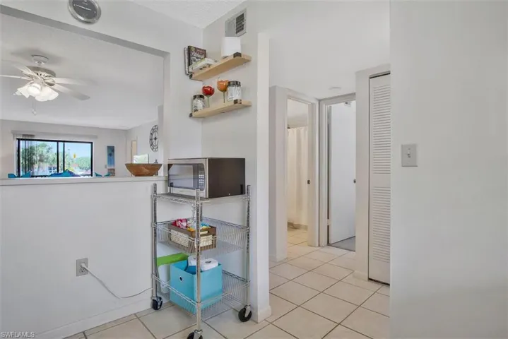 Hall featuring light tile floors and convenient kitchen pass thru