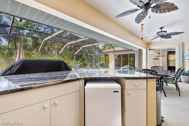 View of patio with ceiling fan and glass enclosure