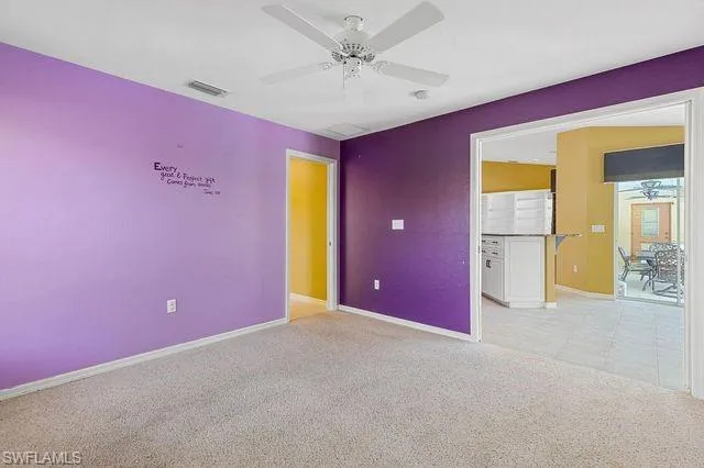 Unfurnished room with light colored carpet and ceiling fan