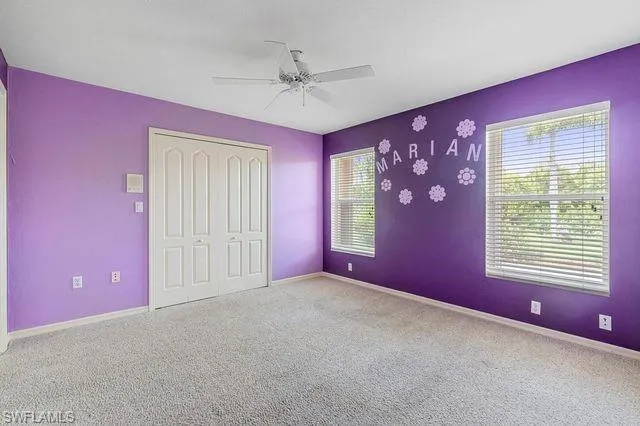 Unfurnished bedroom featuring a closet, carpet floors, and ceiling fan