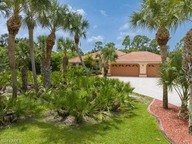 Mediterranean / spanish-style home featuring a garage and a front lawn