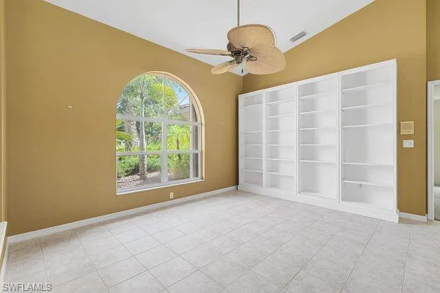 Spare room with ceiling fan, a healthy amount of sunlight, and light tile patterned floors