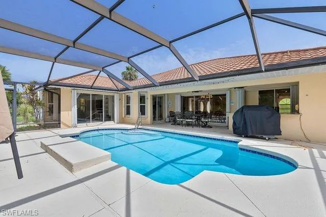 View of swimming pool featuring a patio area, a lanai, grilling area, and ceiling fan
