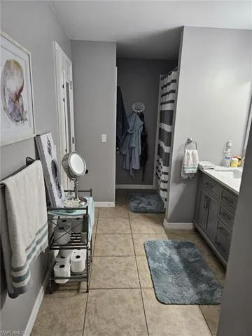 Bathroom with vanity, a shower with curtain, and light tile patterned floors