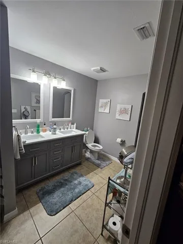 Bathroom featuring double vanity and light tile patterned flooring
