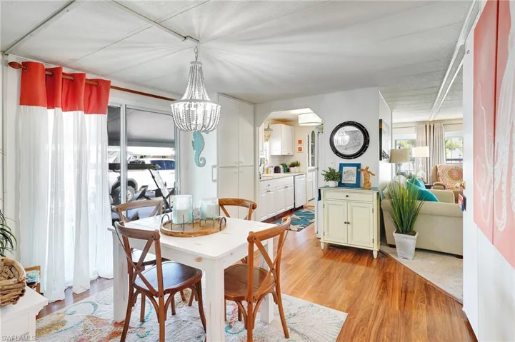 Dining area featuring arched walkways, an inviting chandelier, and light wood-type flooring