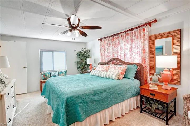 Bedroom with light colored carpet and a ceiling fan