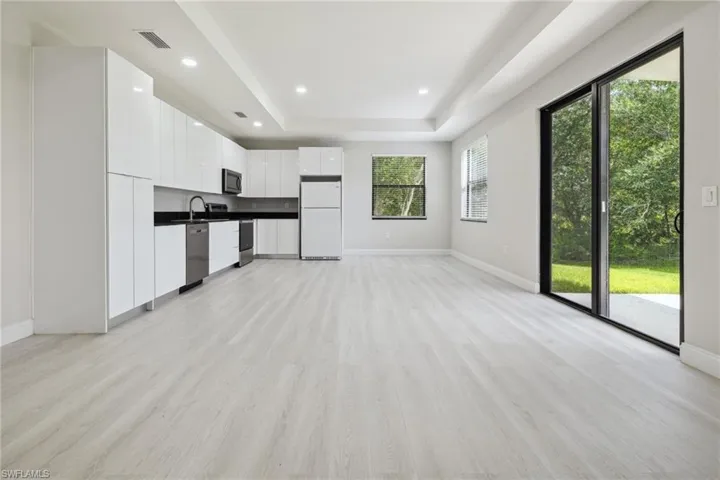 Kitchen with stainless steel appliances, modern cabinets and dark countertops
