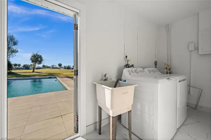 Laundry room with electric panel, plenty of natural light, and washing machine and clothes dryer
