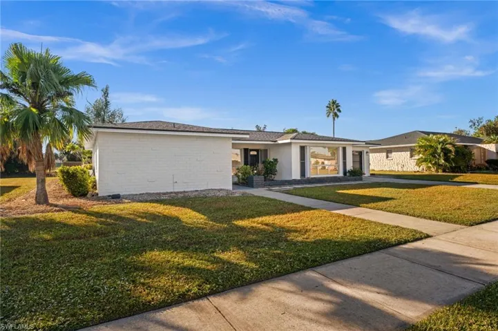 Single story home with a front lawn and brick siding