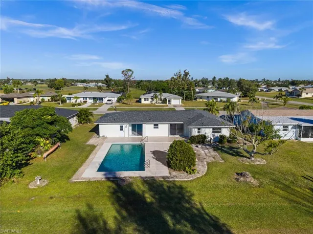 Back of house with a patio, a residential view, an outdoor pool, and a lawn