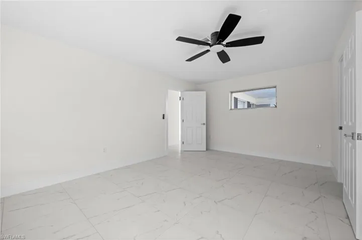 Unfurnished bedroom with ceiling fan and light marble finish flooring