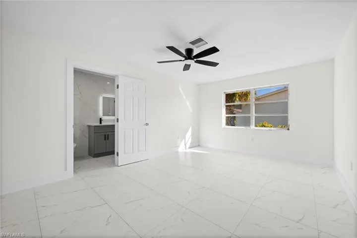 Spare room with light marble finish flooring and a ceiling fan
