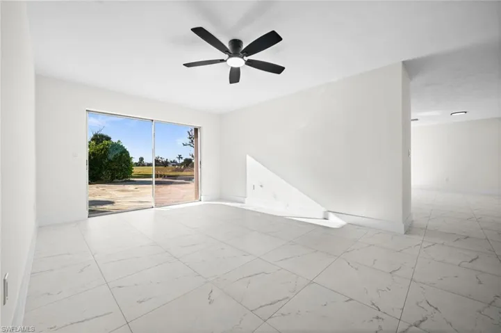 Spare room with light marble finish flooring and a ceiling fan
