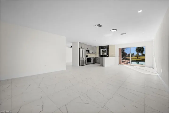 Unfurnished living room with light marble finish flooring and recessed lighting