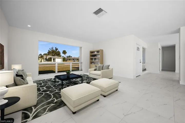 Living room featuring light marble finish flooring and recessed lighting
