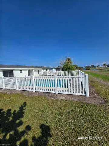 Rear view of house featuring a lawn and a pool