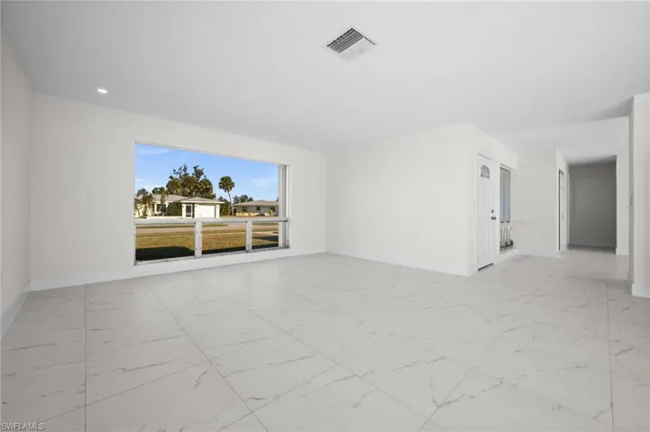 Spare room featuring baseboards and light marble finish floors