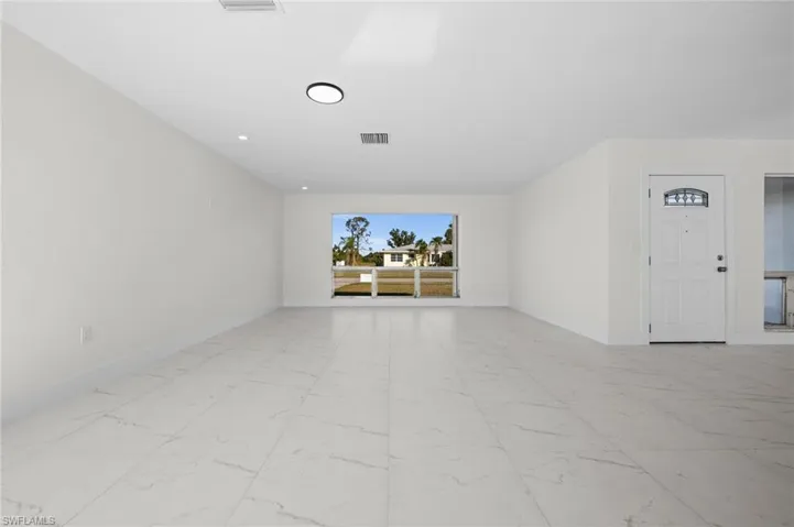 Spare room with light marble finish floors and recessed lighting
