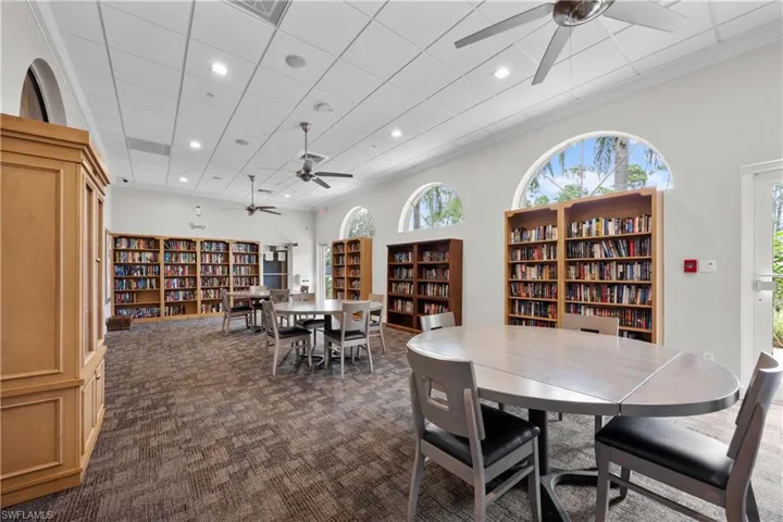Dining room featuring ceiling fan, crown molding, dark carpet, and a high ceiling