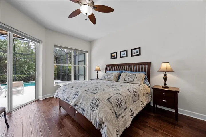 Bedroom with access to exterior, dark hardwood / wood-style flooring, and ceiling fan