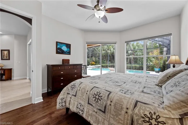 Bedroom with hardwood / wood-style floors, access to outside, and ceiling fan