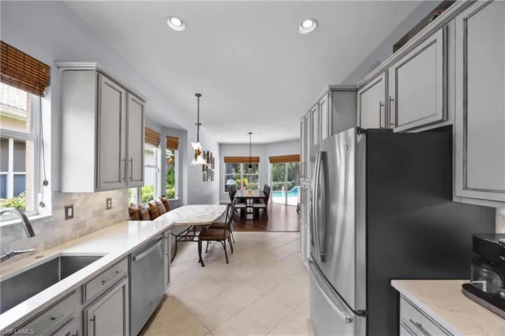 Kitchen with custom cabinetry, light tile patterned floors, and plenty of natural light