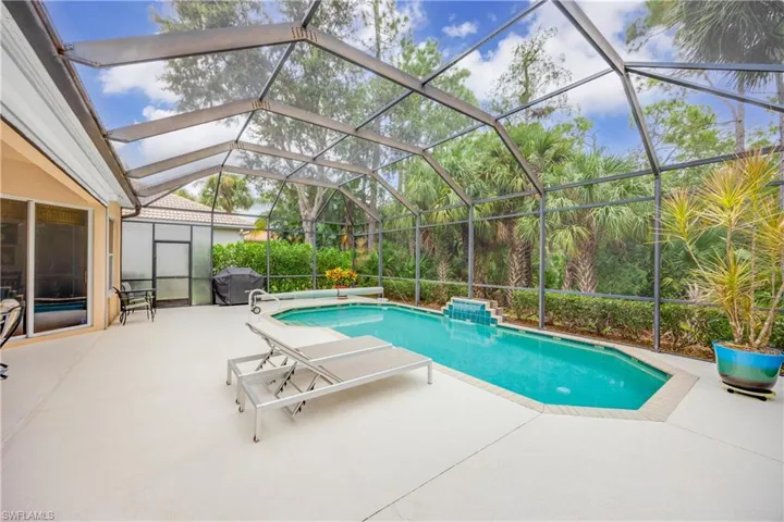 View of swimming pool featuring glass enclosure and a patio area