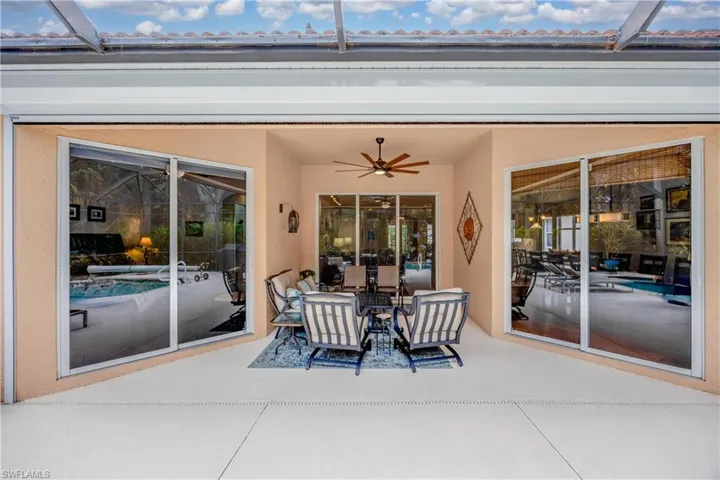 View of patio featuring ceiling fan and a lanai