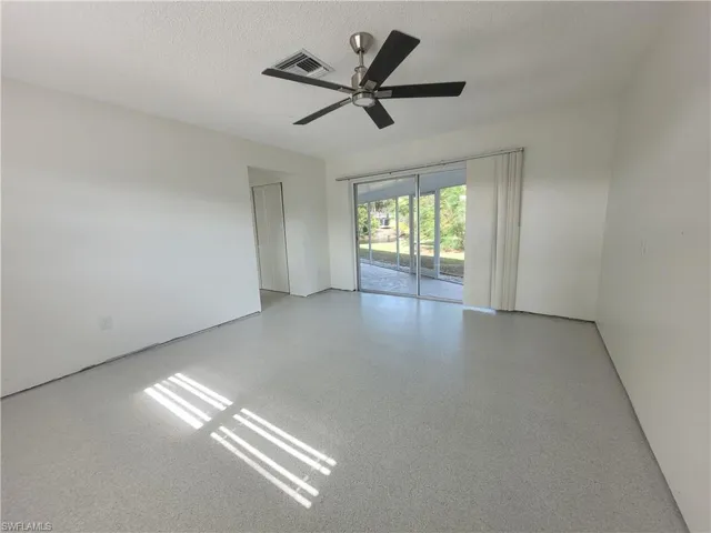Spare room with speckle patterned floor, a textured ceiling, and ceiling fan