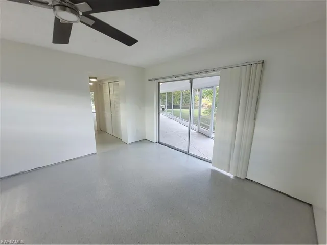 Unfurnished room featuring a textured ceiling, speckled floor, and a ceiling fan