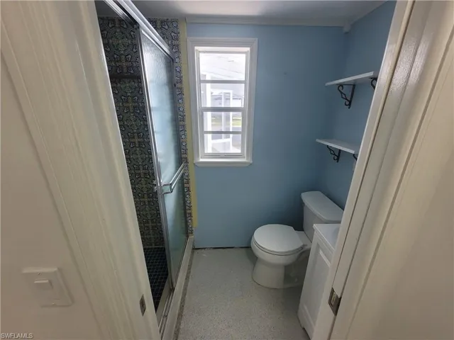 Bathroom featuring a shower stall, vanity, and crown molding