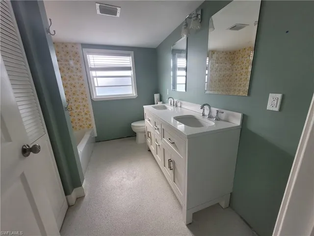 Bathroom featuring double vanity and bathtub / shower combination