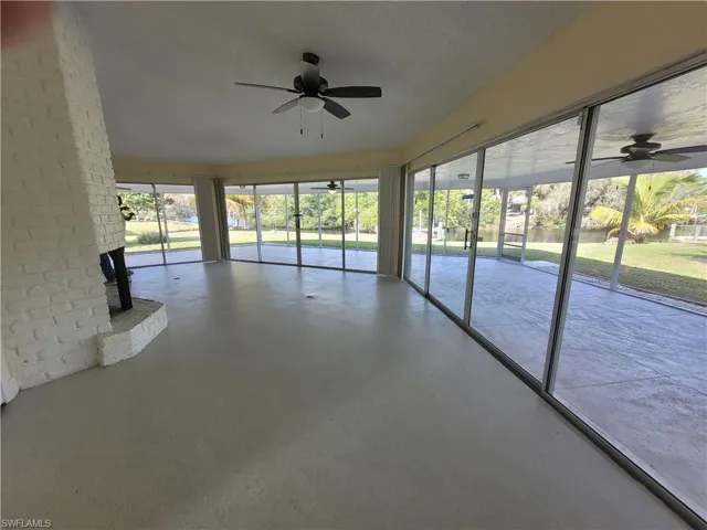 Unfurnished sunroom featuring ceiling fan