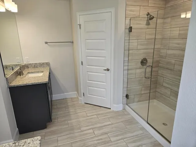 Bathroom with vanity and a shower with shower door