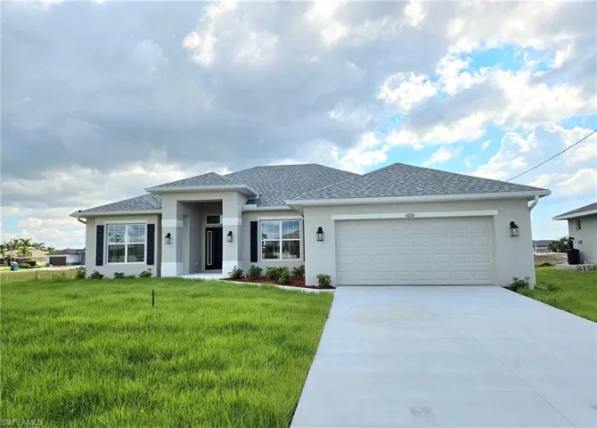 View of front of home with a front yard and a garage