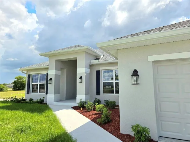 Property entrance featuring a yard and a garage