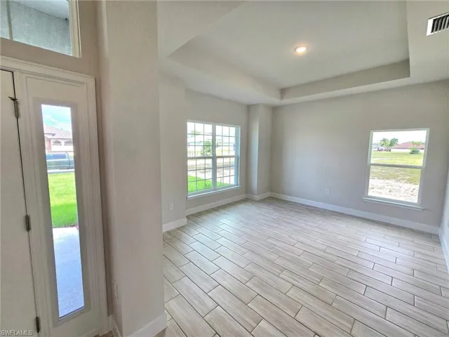 Entryway featuring light wood-type flooring and a raised ceiling