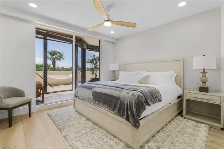 Bedroom with light hardwood / wood-style flooring, access to outside, and ceiling fan