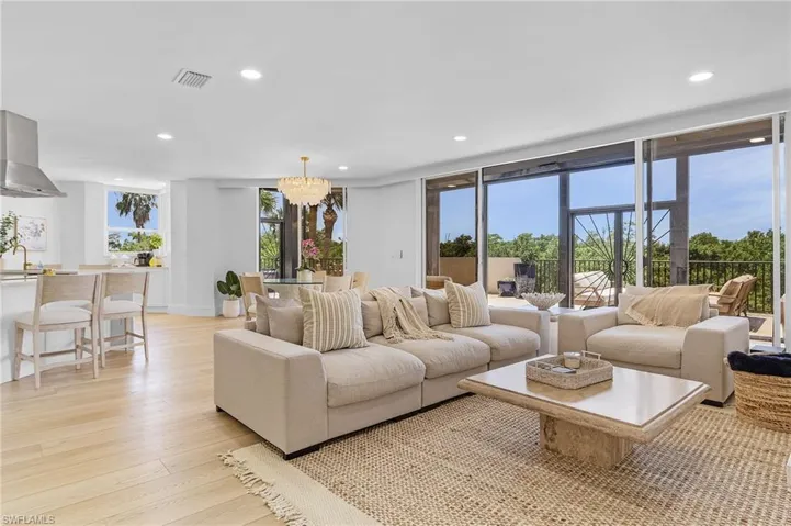Living room featuring a notable chandelier, sink, and light wood-type flooring